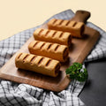 Peanut Butter Sausage Roll for Dogs  Baked goods on a wooden board with a checkered cloth underneath